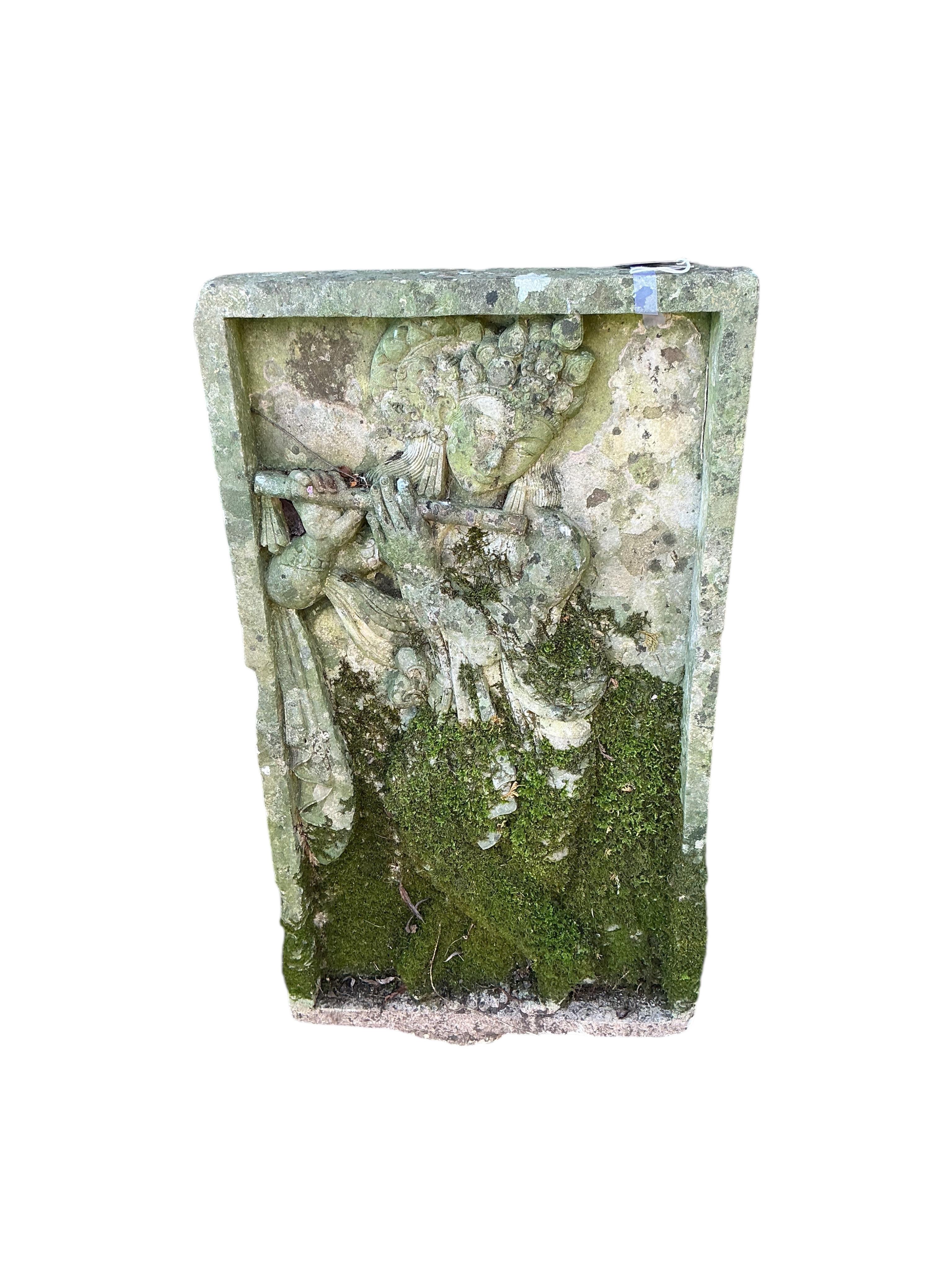 A reconstituted stone relief panel of Krishna playing the flute, width 50cm, height 90cm